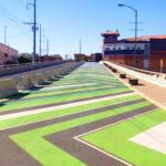 Image of Downtown Pathways pedestrian walkway in El Paso. The path is painted in green and white chevron.