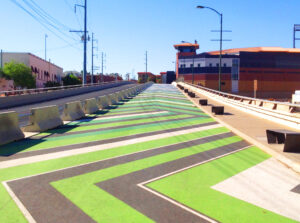 Image of Downtown Pathways pedestrian walkway in El Paso. The path is painted in green and white chevron.
