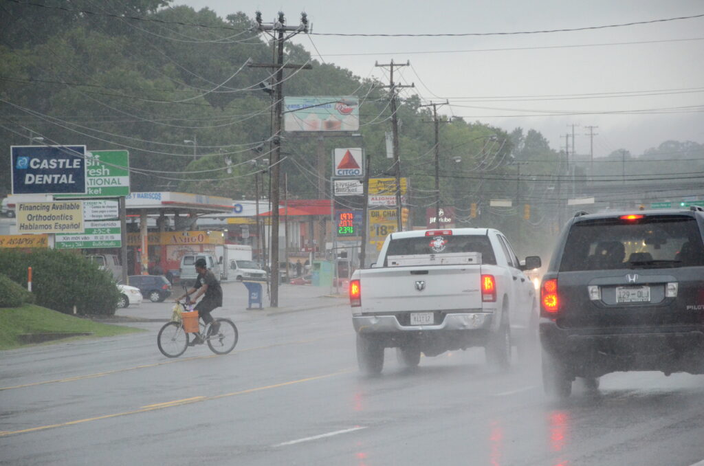 Image of cyclist crossing busy street in the rain in Nashville, Tennessee