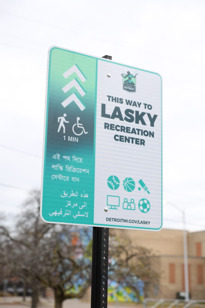 Image of teal and white sign featuring the Detroit logo that directs people to Lasky Recreation Center.