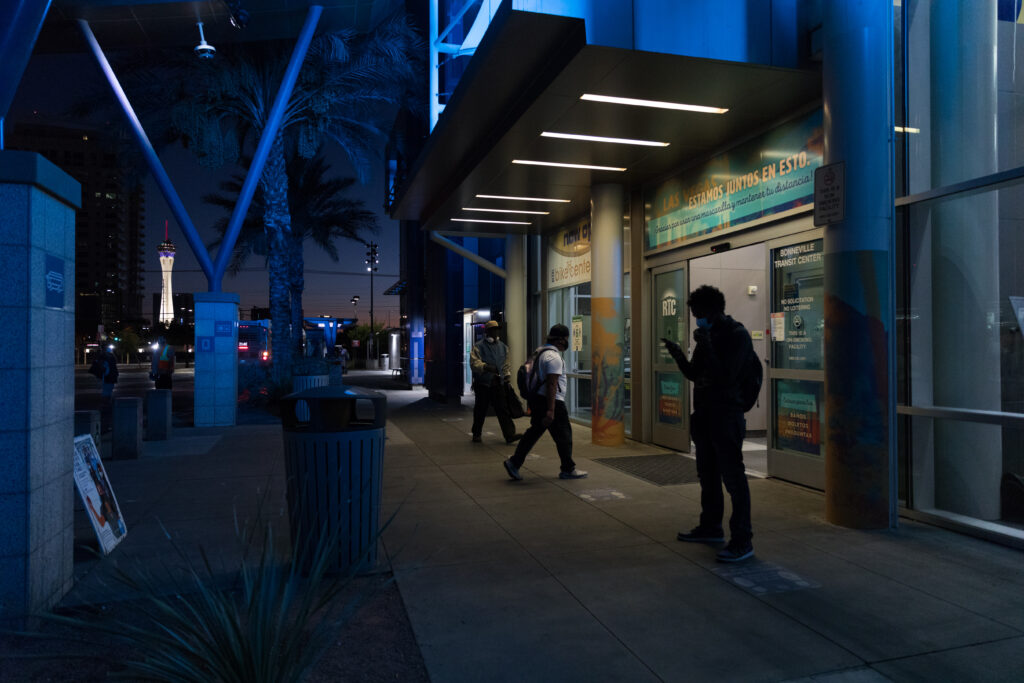 Image of the entrance of Bonneville Transit Center at night featuring vinyl signs on glass doors that read “Estamos juntos en esto.”