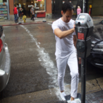 man in all white outfit walking across a street leaving white footprints