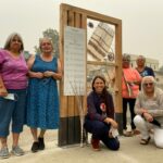 Photo of women standing around and beside their outdoor engagement installation